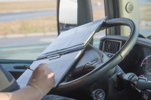 driver writing while sitting at steering wheel